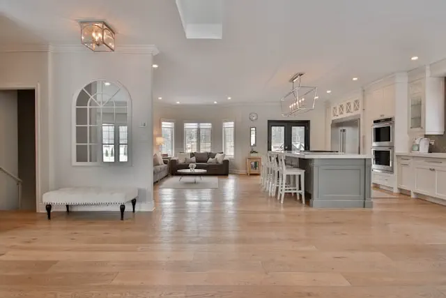 Flooring service in the Dubai featuring a spacious modern interior with premium wooden flooring, open plan kitchen, and seamless installation across living areas