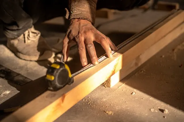 Trim molding service in the Dubai showing a carpenter measuring and cutting wooden trim with precision tools for accurate fitting and professional finish